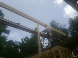 Carpenter setting a ridge beam over a new addition frame — Ice Dam Removal by Roofing Brothers in Veradale