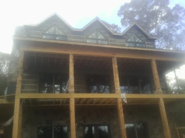 Dormers and porch framing on a large log home under construction — Roof Coating work by our crew in Veradale